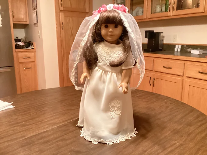 18-inch doll wearing a handmade ivory bridal gown with lace appliqué and a flower crown veil