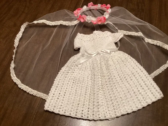 White crochet doll bridal gown with satin bow, tulle veil and pink flower crown