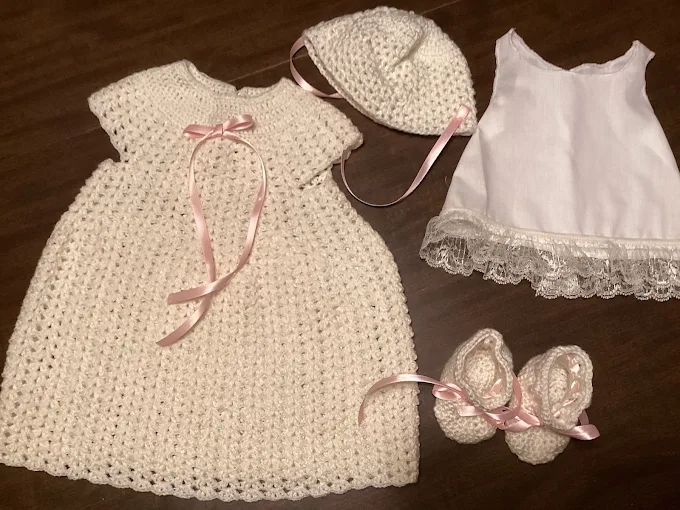 Cream crochet doll gown with pink ribbon, matching bonnet, lace slip and booties